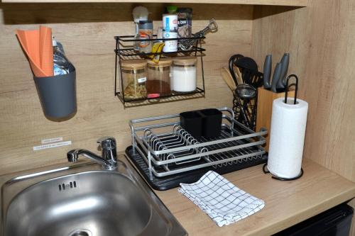 a kitchen counter with a sink and a dish drying rack at Metkina Hiška -samooskrbna in Topovlje