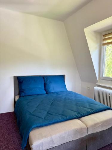 a blue bed in a room with a window at Penzion Horní Bradlo in Horní Bradlo
