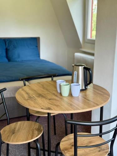 a table with two chairs and a coffee pot on it at Penzion Horní Bradlo in Horní Bradlo