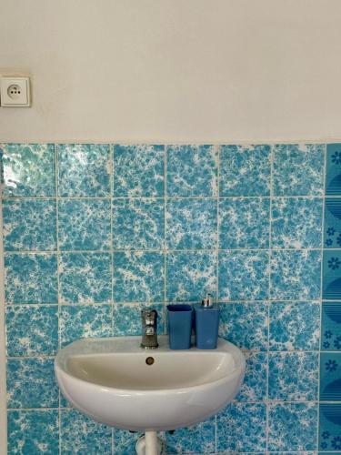 a bathroom with a sink and blue tiles at Penzion Horní Bradlo in Horní Bradlo