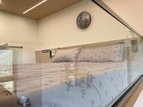 uma cama num quarto com um relógio na parede em 浮雲投影海景溫泉 em Toucheng