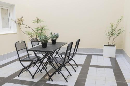 a table and chairs in a room with potted plants at Hotel Cap Polonio in Ushuaia