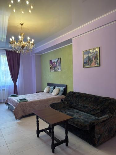 a living room with a couch and a bed at SunLake Hotel Osokorki in Kyiv