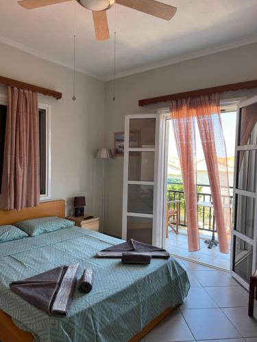 a bedroom with a bed with a fan and a balcony at Christina Sea View in Ágios Konstantínos