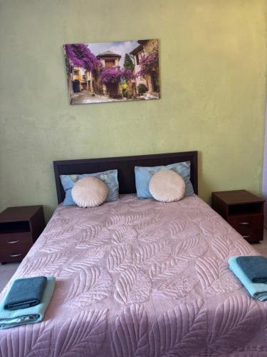 a purple bed with two pillows and a laptop on it at SunLake Hotel Osokorki in Kyiv