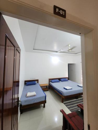a room with two beds and a sign that readsfor at Happyhomes Homestay in Trivandrum
