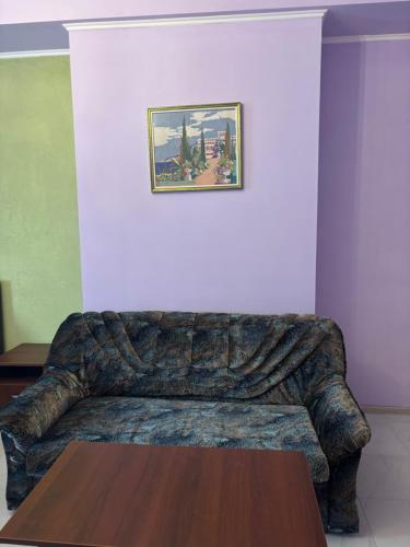 a couch in a living room with a table at SunLake Hotel Osokorki in Kyiv