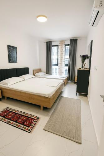 a bedroom with two beds and a large window at Flat in Orikum Beach in Orikum
