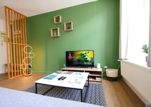 - un salon avec des murs verts et une table basse dans l'établissement Le Charme des Remparts Boulonnais, à Boulogne-sur-Mer