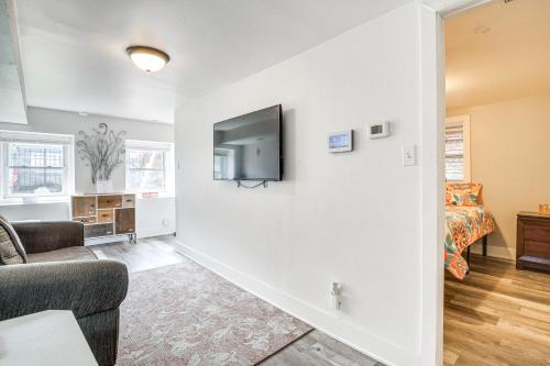 a living room with a couch and a tv on a wall at Dog-Friendly Apt with Yard 10 Mi to Downtown in Chicago