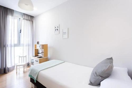 a white bedroom with a bed and a window at Amazing, Sea Views & Terrace in Santa Úrsula