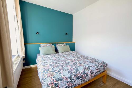 a bedroom with a bed with a blue wall at Le Charme des Remparts Boulonnais in Boulogne-sur-Mer