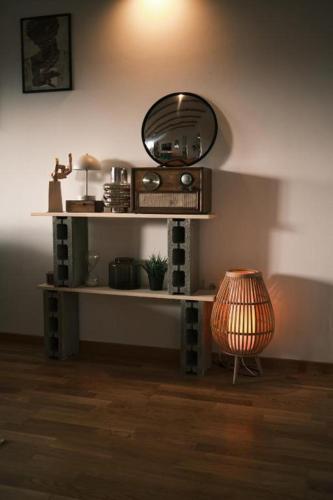 a room with a shelf with a mirror and a lamp at Ikigai Penthouse Apartment in Banja Luka