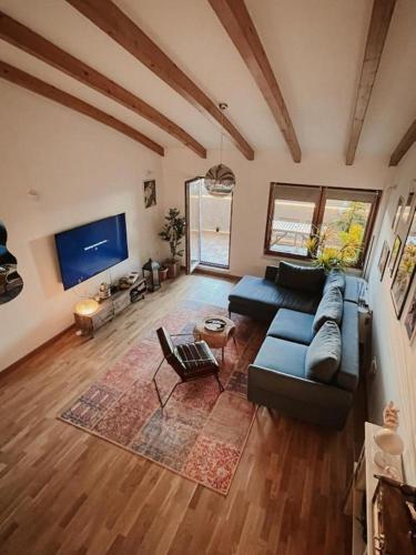 a living room with a blue couch and a tv at Ikigai Penthouse Apartment in Banja Luka