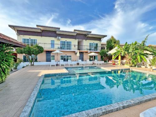 a swimming pool in front of a building at Anyavee Chom By The Sea in Ao Nam Mao