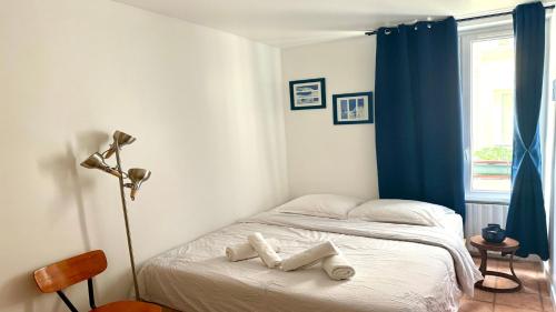 une chambre avec un lit avec deux serviettes blanches dessus dans l'établissement Charming Apartment near The Eiffel Tower, à Paris