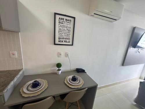a table in a kitchen with two plates on it at Manaíra Apart Hotel in João Pessoa