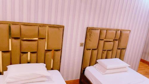 two beds in a room next to each other at Sapphire Suites in Karachi