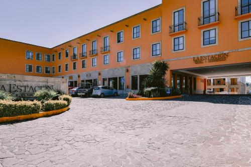 a large orange building with a parking lot at Hotel La Estación in San Miguel de Allende