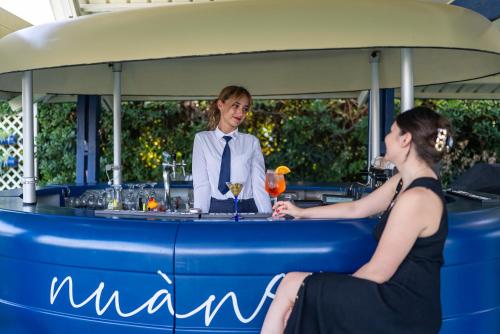 a man and a woman sitting at a bar at Hotel Negresco in Lido di Jesolo