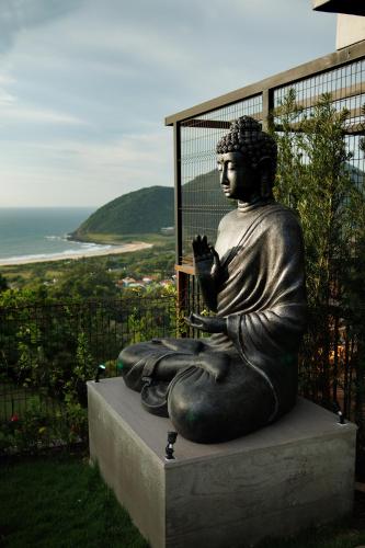 a statue of a woman sitting on top of a hill at Casa Yogui Brasil in Garopaba