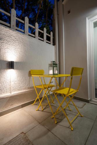 a yellow table and two chairs on a patio at Jardin maison in Itea