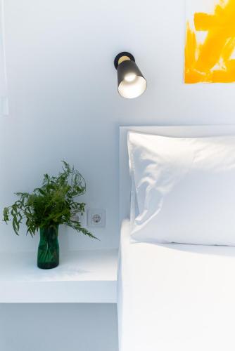 a vase sitting on a shelf next to a bed at Jardin maison in Itea