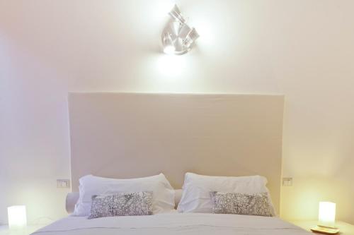 a bedroom with a white bed with two pillows at Exclusive Aparthotel La Reunion in Ravenna