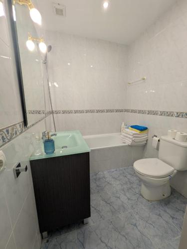 a bathroom with a toilet and a tub and a sink at El HORTAL in Alberite
