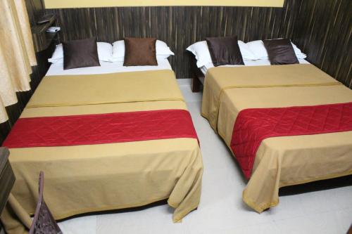 two beds in a hotel room withskirts at Shaan stay inn in Kanchipuram