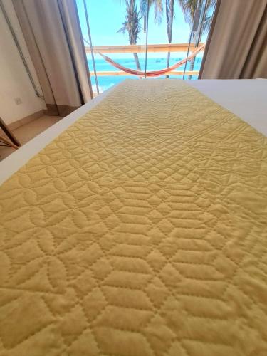 a large bed in a room with a view of the ocean at H0TELIER Home, Máncora in Máncora
