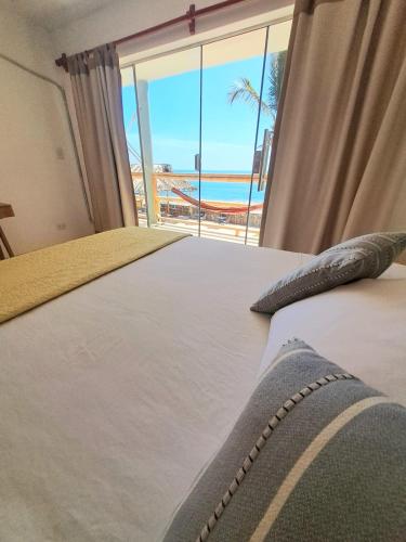 a bedroom with a bed with a view of the beach at H0TELIER Home, Máncora in Máncora