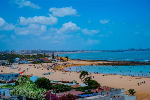 a beach with a bunch of people in the water at Cozy Appartement Relax in Mohammedia