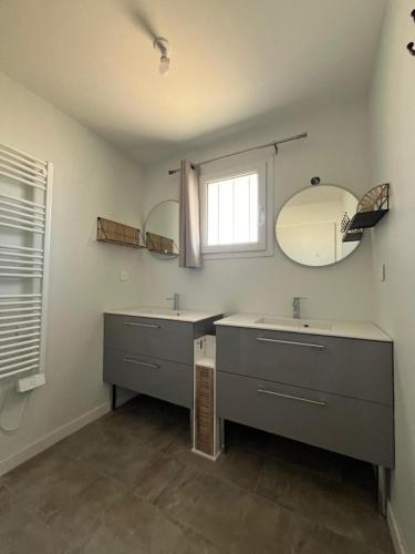 La salle de bains est pourvue de 2 lavabos, de miroirs et d'une fenêtre. dans l'établissement Location maison balnéaire 8 couchages 50m plage du Cormier, à La Plaine-sur-Mer