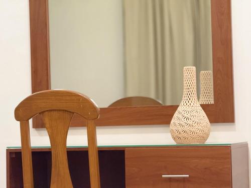 a table with a chair and a vase on it at Casa Mayahuel in Oaxaca City