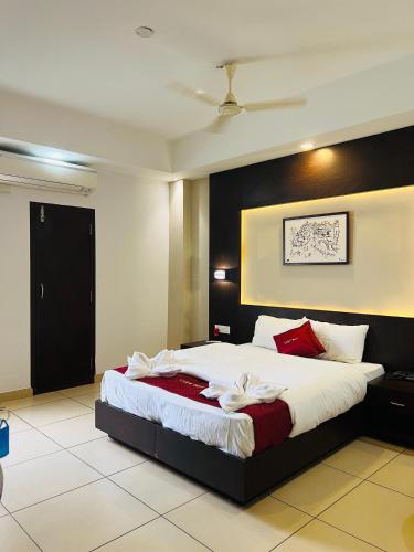 a bedroom with a large bed with red and white pillows at Luxebay in Bangalore