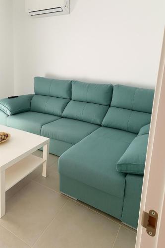 a blue couch in a living room with a table at Alojamiento Baeza California 2B in Baeza