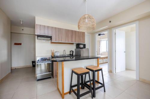 a kitchen with a counter and some stools in it at 2-Bedroom Retreat in Avida Riala Prime Location in Cebu City