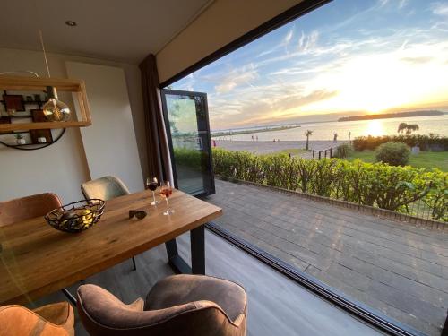 jadalnia ze stołem i widokiem na plażę w obiekcie BEACH VILLA in erster Reihe - direkter Strandzugang - eingezäunter Garten - Dachterrasse - 2 Gartenterrassen - Terrassendach - Grill mit Plancha - XXL Meerblick - Bar - SONOS Soundanlage - Pool Whirlpool - kinderfreundlich - Hunde willkommen w mieście Hulshorst