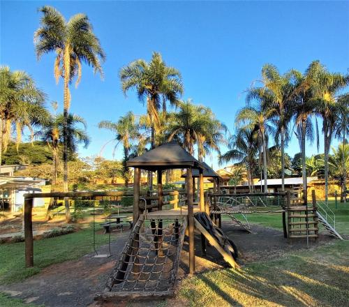 a playground in a park with palm trees at Apartamento Verde in Avaré