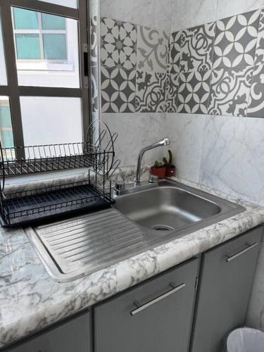 a kitchen counter with a sink and a window at Suites Incoreli in Pachuca de Soto