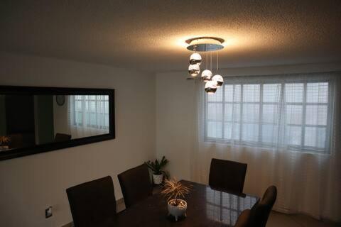 a dining room with a table and a mirror at Suites Incoreli in Pachuca de Soto