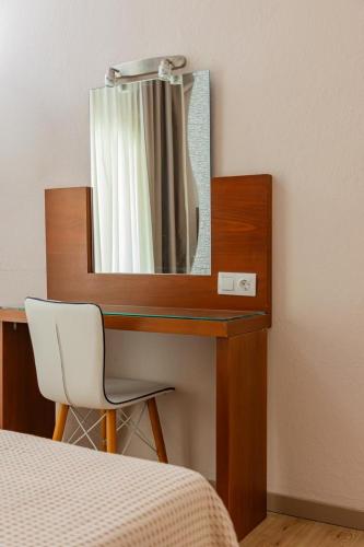 a bedroom with a desk with a mirror and a chair at Del Mar Sithonia Studios&Apartments in Neos Marmaras