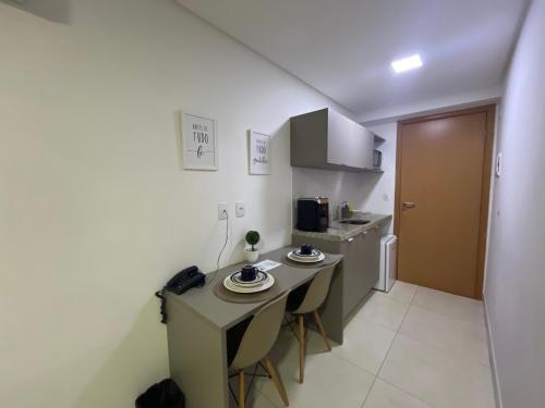 a small kitchen with a table and chairs in a room at Manaíra Apart Hotel in João Pessoa