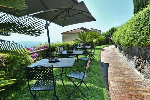 a row of tables and chairs with an umbrella at Kemì Luxury Suites in Vietri sul Mare