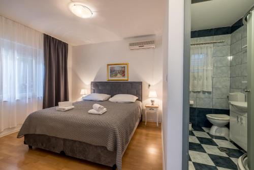 a bedroom with a bed and a bathroom with a toilet at Guesthouse Rooms Split in Split