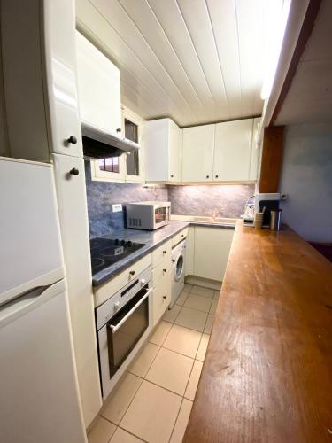 a kitchen with white cabinets and a stove top oven at Studio front de mer Valras-Plage 2-4 personnes in Valras-Plage