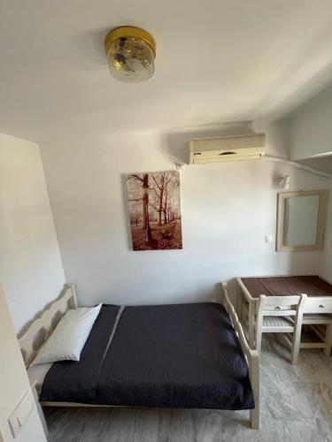 a small bedroom with a bed and a desk at Panorama Hotel in Kalymnos