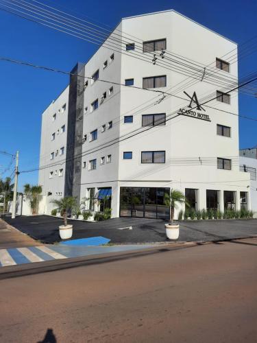 Un edificio blanco con una calle enfrente. en Hotel Acanto, en Rio Verde