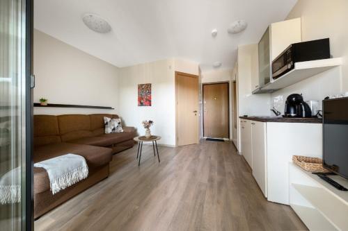 a living room with a couch and a kitchen at Cozy Mill apartment in Palanga
